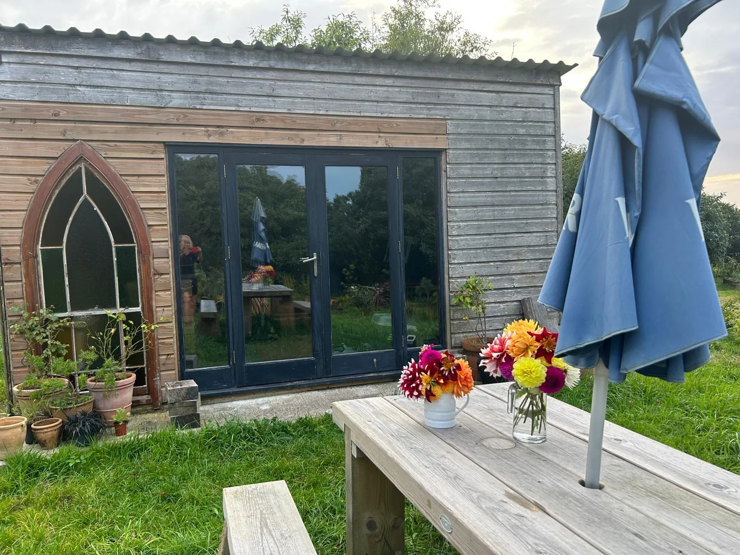 A timber garden room with colourful flowers outside